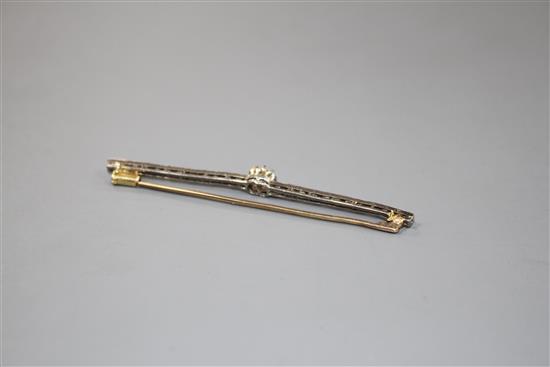 A 1920s yellow and white metal, diamond bar brooch, with central old cut diamond and millegrain set rose cut diamonds,